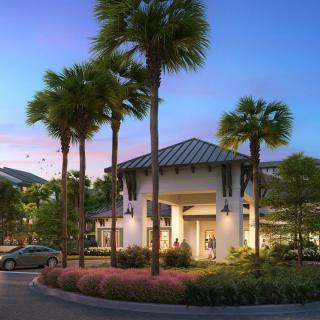 A modern building surrounded by palm trees, captured during sunset.