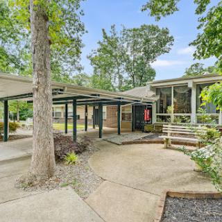 A tranquil outdoor space featuring modern architecture surrounded by lush greenery.