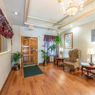 A welcoming lobby featuring wooden flooring, decorative plants, and comfortable seating areas.