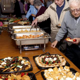A group of seniors enjoying a buffet-style meal at a community event.