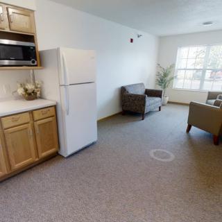 A cozy studio apartment with a kitchen and living area featuring modern furniture and bright natural lighting.