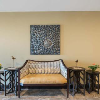A stylish living room setup featuring a patterned sofa and two side tables, with decorative artwork adorning the wall.
