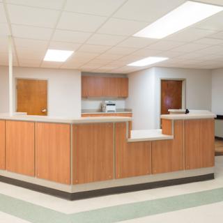 A modern reception area in a healthcare setting, featuring wooden countertops and a clean, organized layout.