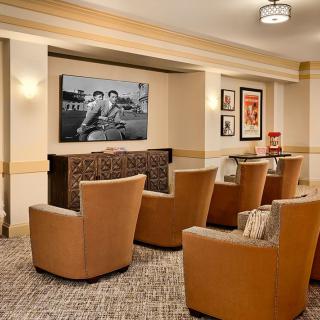 A cozy movie room with comfortable theater seating and a large television.