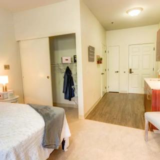 A cozy bedroom with a bed, closet, and lamp, highlighting clean interior design.