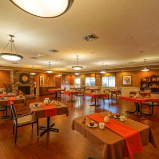 A cozy and inviting dining area with tables set for meals, featuring warm colors and ambient lighting.