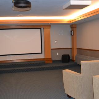 A cozy home theater setup with a large screen and comfortable seating.