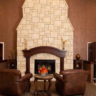 A cozy living room featuring a stone fireplace and comfortable leather chairs.