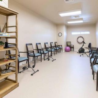 A rehabilitation exercise room with chairs and fitness equipment.