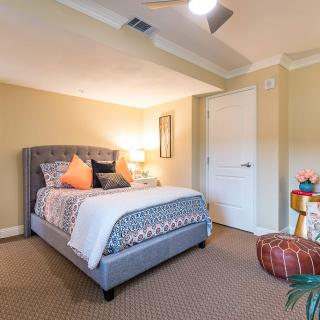 A cozy bedroom with a neatly made bed and warm lighting.