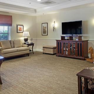 A cozy living room featuring a sofa, television, and framed artwork.