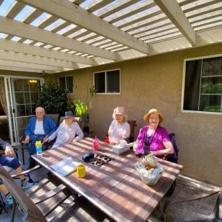 A group of people enjoying a sunny day on the patio.
