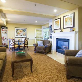 A cozy living room with a fireplace, comfortable seating, and a small dining area.