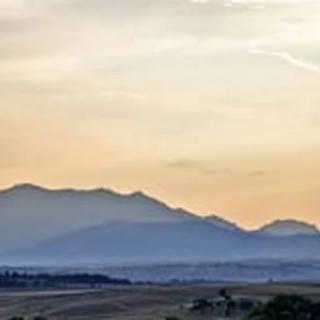 A serene view of mountains at sunset with a soft, colorful sky.
