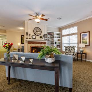 A cozy living room featuring a fireplace, sofa, and decorative elements.