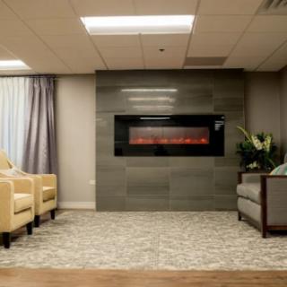 A modern lounge area featuring a central fireplace, comfortable seating, and stylish decor.