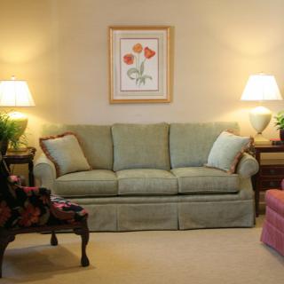 A cozy living room with a green sofa and warm lighting.