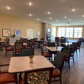 A spacious and well-lit dining room with neatly arranged tables and chairs.