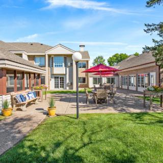 A tranquil outdoor courtyard featuring comfortable seating and well-maintained landscaping.