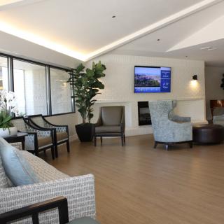 A modern waiting room with comfortable seating and a television.