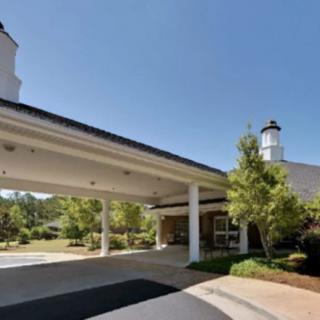 A building entrance with an overhang and surrounding greenery.