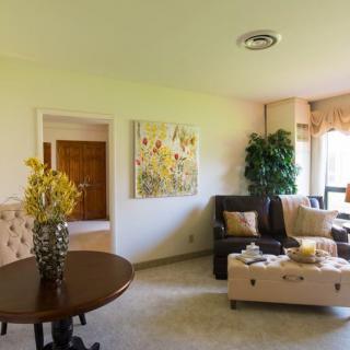 A cozy living room with a sofa, coffee table, and decorative elements like artwork and plants.
