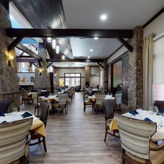 A spacious and elegantly designed restaurant dining area with neatly arranged tables and chairs.