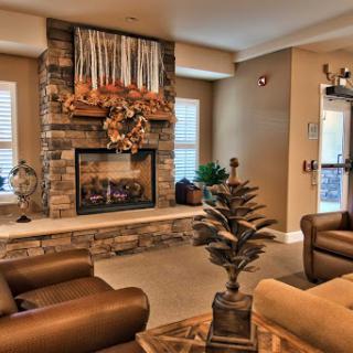 A cozy living room featuring a stone fireplace, comfortable seating, and decorative elements for a warm ambiance.