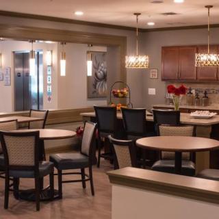 A modern dining area with tables and chairs, featuring elegant lighting and decor.