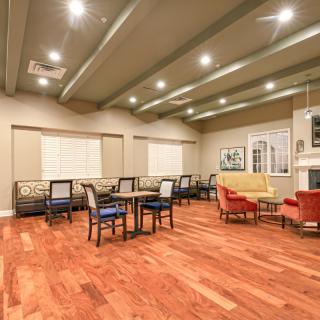 A modern dining area with wood flooring, tables, and ceiling lights.