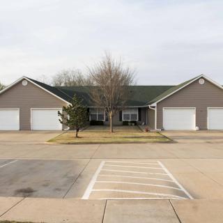 A suburban house with two garages and a central driveway.