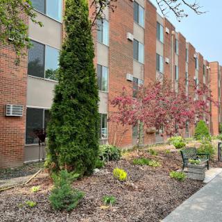 A well-maintained exterior view of an apartment building with landscaped gardens.