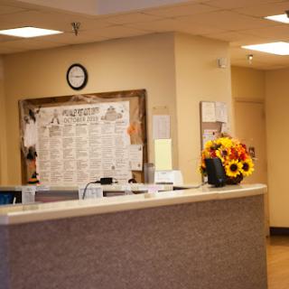 A welcoming reception area with a floral arrangement and an informational board.