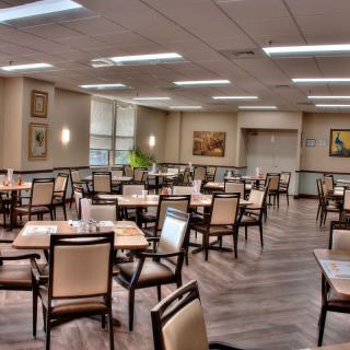 An empty dining room with neatly arranged tables and chairs.