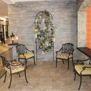A cozy patio with iron furniture and decorative plants on the wall.