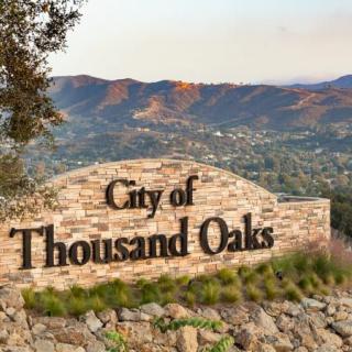 Welcome sign at the entrance to the City of Thousand Oaks, with scenic mountain backdrop.