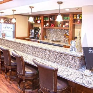 A cozy bar interior with a stone countertop and comfortable seating.