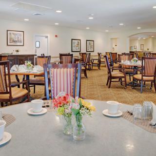 An elegant dining room with neatly arranged tables and chairs, featuring a warm and welcoming ambiance.