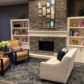 A cozy living room with a stone fireplace, comfortable seating, and stylish decor.