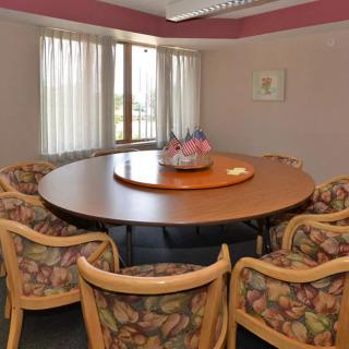 A round conference table surrounded by chairs in a meeting room.