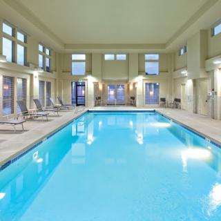 A serene indoor swimming pool featuring elegant design and comfortable lounging spaces.