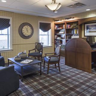 A cozy office space with a bookshelf and a clock on the wall.