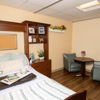 A cozy and well-furnished living space with a bed, seating area, and decorative elements.