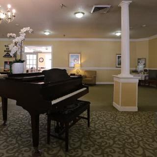 A well-decorated lobby featuring a grand piano and an elegant seating area.