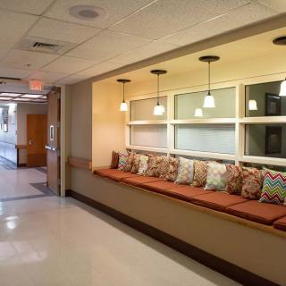 A cozy seating area with colorful pillows along a hallway.