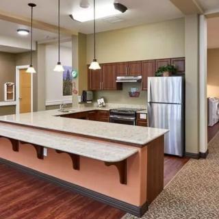 A modern kitchen with a spacious countertop, pendant lights, and stainless steel appliances.