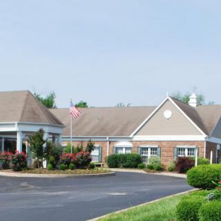 A suburban residential building with well-maintained landscaping and a spacious driveway.