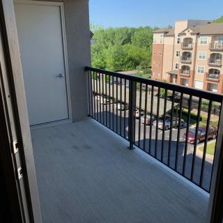 A sunny apartment balcony with a view of neighboring buildings.