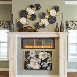 A stylish fireplace with modern wall art and floral decorations.