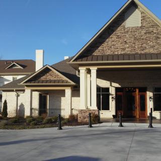 A residential building with a pitched roof and landscaped entrance.